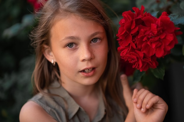 Linda menina bonitinha com dentes tortos perto de uma rosa