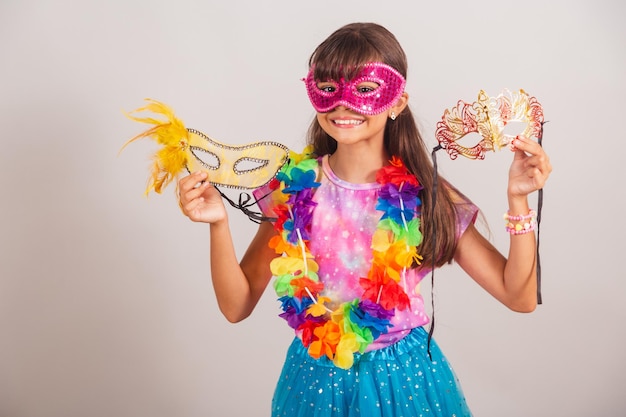 Linda menina brasileira vestida para o carnaval no Brasil com máscara de carnaval segurando máscaras convidando para a festa