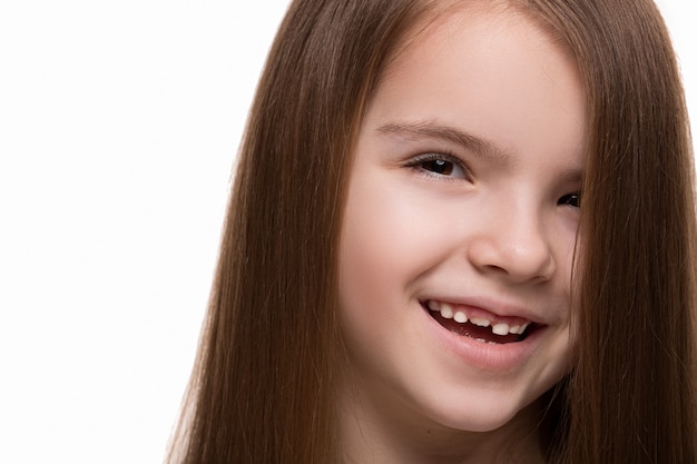 Linda menina caucasiana com longos cabelos escuros feliz sorrindo no estúdio. Fundo branco isolado
