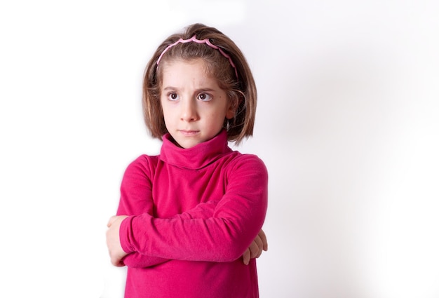 Linda menina chateada em pé isolada sobre fundo branco