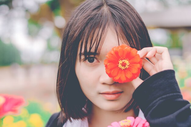 Linda menina com flores no jardim.