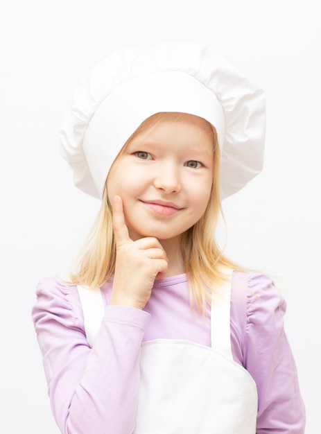 Linda menina com uniforme de chef isolado no branco