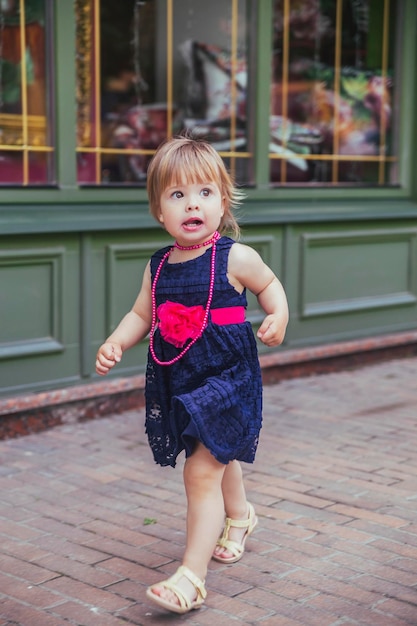 linda menina de vestido correndo pela rua