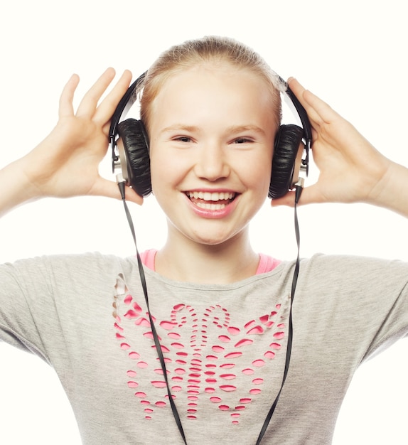 Linda menina feliz com fones de ouvido. Isolado no branco.