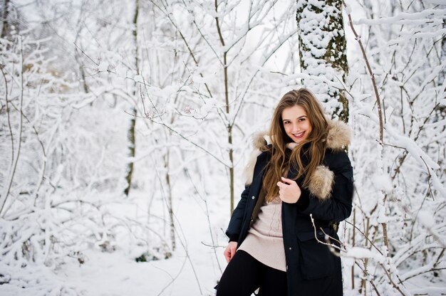 Linda menina morena em roupas quentes de inverno. Modelo de jaqueta de inverno.