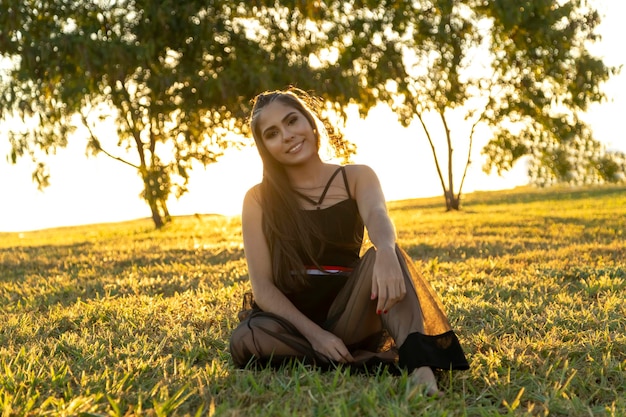 Foto linda menina morena posando em fotos na natureza ao pôr do sol