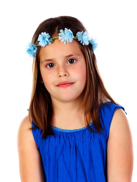 Linda menina pequena com vestido azul e uma coroa de flores na cabeça dela