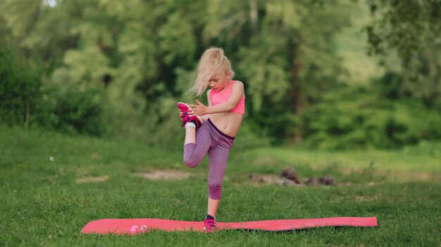 Linda menina ucraniana de 7 anos com cabelos brancos como um anjo está envolvida em fitness