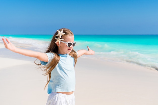 Linda menina vestido na praia se divertindo. Garota engraçada Aproveite as férias de verão.