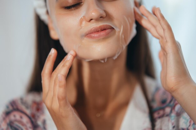 Linda modelo aplicando creme cosmético no rosto