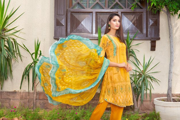 Linda modelo menina paisagem usando vestido amarelo Desi para sessão de fotos de moda