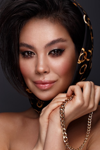 Foto linda modelo morena asiática com cachos volumosos, maquiagem clássica e lábios sensuais