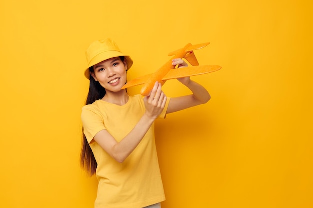 Linda morena de chapéu com um avião nas mãos modelo de brinquedo isolado fundo inalterado