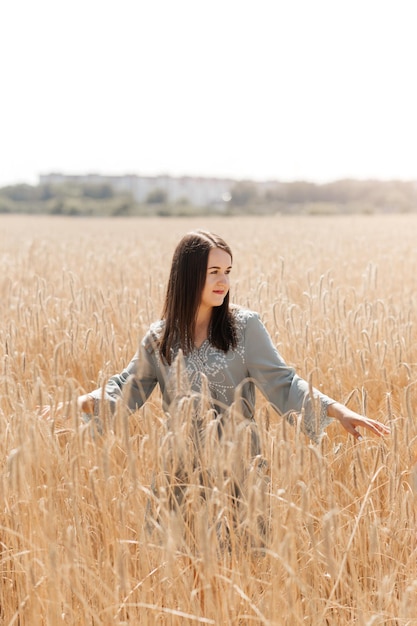 Linda morena em pé em um campo de trigo