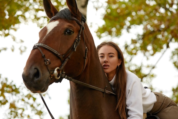 Linda morena em um cavalo no fundo de uma paisagem de outono Andar a cavalo equitação ativa