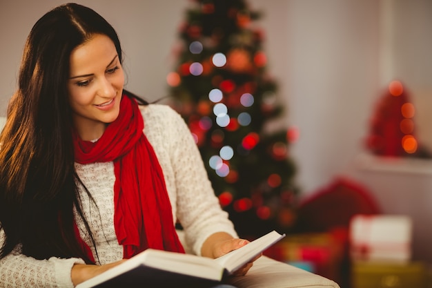 Linda morena lendo no sofá no natal