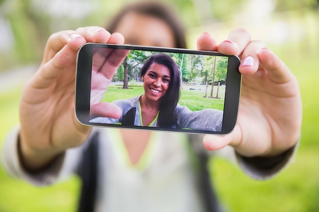 Foto linda morena pegando um selfie no parque