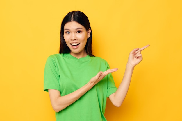 Linda morena posando em camiseta verde emoções copyspace fundo amarelo inalterado