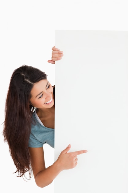 Foto linda mujer apuntando a un tablero