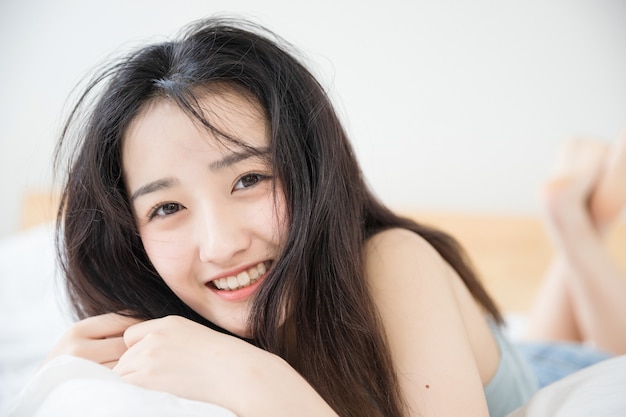 Foto linda mujer asiática descansando en la cama