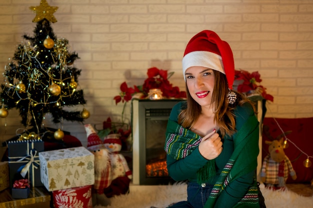 Linda mujer en casa disfrutando de la noche de navidad en un ambiente hogareño y acogedor