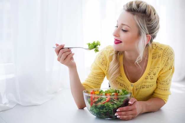 linda mujer en casa con ensalada