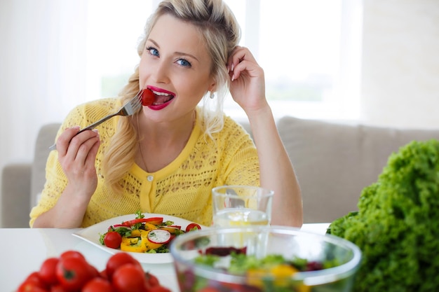 linda mujer en casa con ensalada