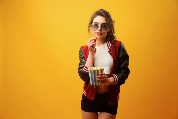 Linda mujer comiendo palomitas de maíz en estudio