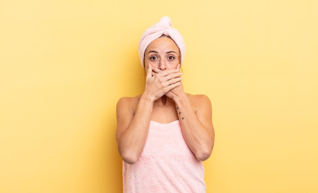 Linda mujer cubriendo la boca con las manos con una ducha conmocionada y un concepto de belleza