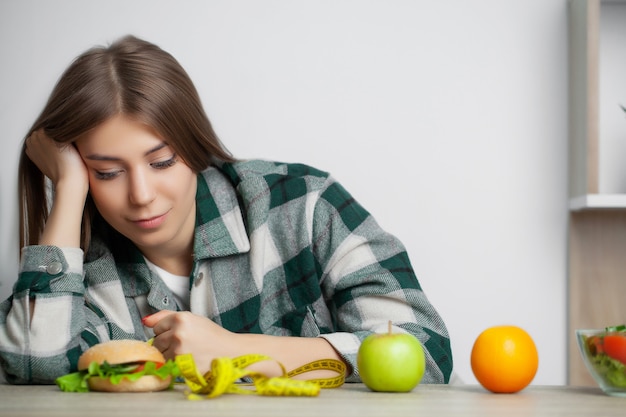 Foto linda mujer elige entre alimentos saludables y nocivos