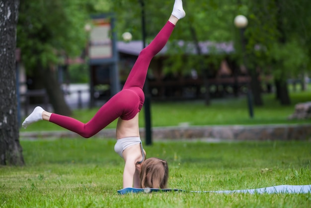 Linda mujer haciendo ejercicios de yoga en el parque