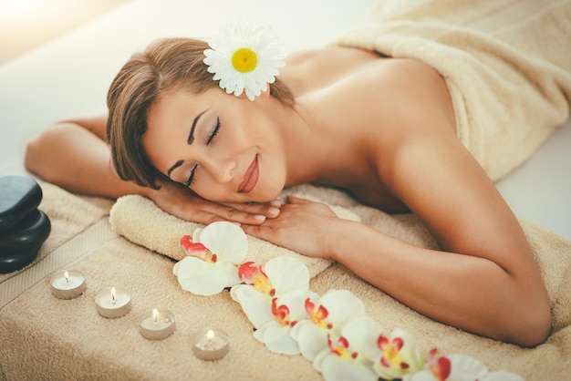 Linda mujer joven está disfrutando durante un tratamiento de cuidado de la piel en un spa.