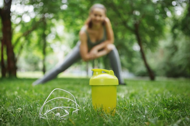 Linda mujer joven haciendo ejercicios de yoga en un parque verde