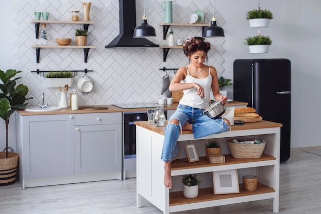 Linda mujer joven haciendo masa en la cocina