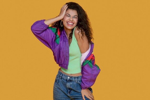 Linda mujer joven de pelo oscuro en chaqueta brillante mirando alegre