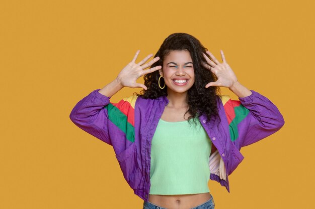 Foto linda mujer joven de pelo oscuro en chaqueta brillante sonriendo felizmente