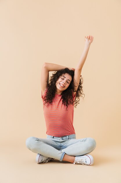 Foto linda mujer joven sentada estiramiento aislado.