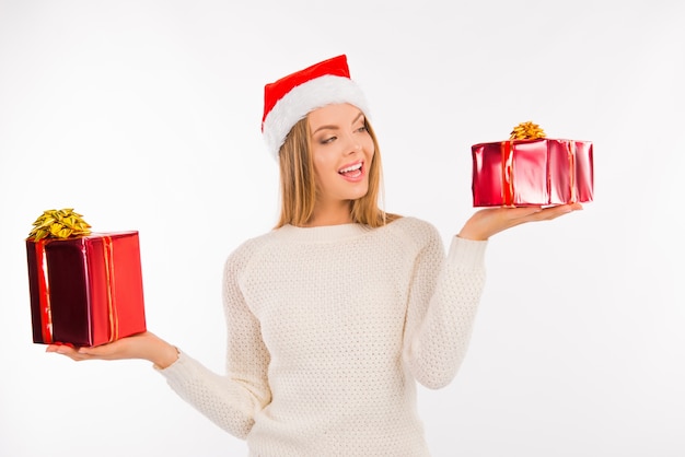 Linda mujer joven con sombrero de santa elegir regalos de Navidad