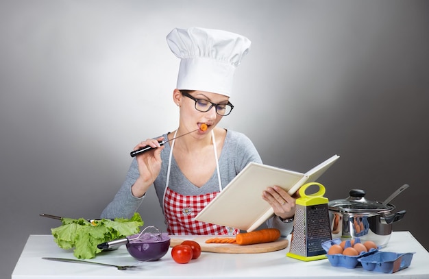 Linda mujer leyendo cocinar con libro de cocina