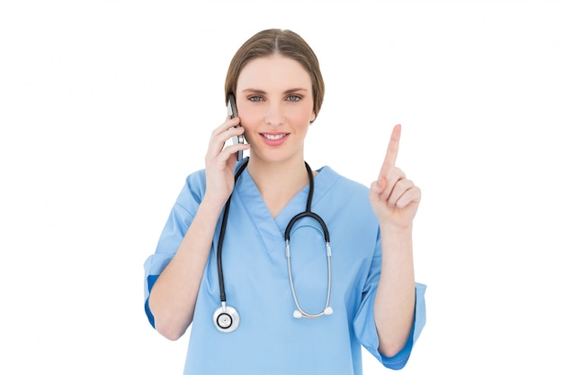 Linda mujer médico llamando y apuntando con su dedo