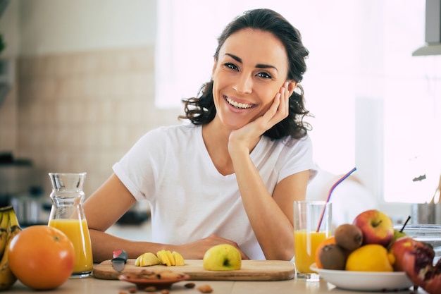 Linda mujer morena joven hermosa y feliz en la cocina