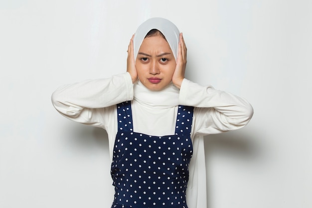 Linda mujer musulmana asiática vistiendo hijab tapándose las orejas