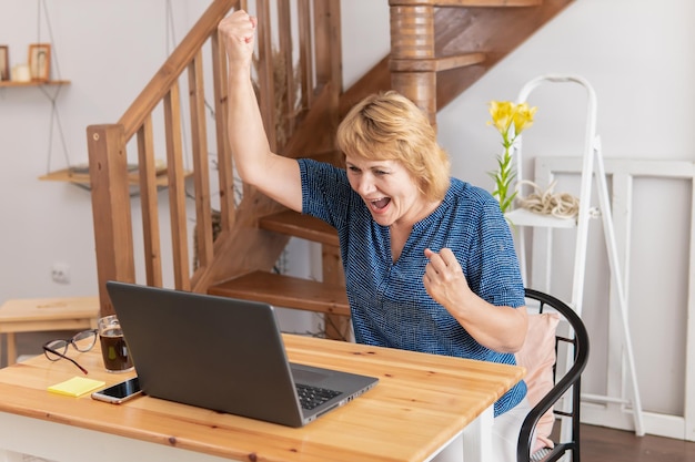 Linda mujer en la oficina sentada en un escritorio con una computadora portátil