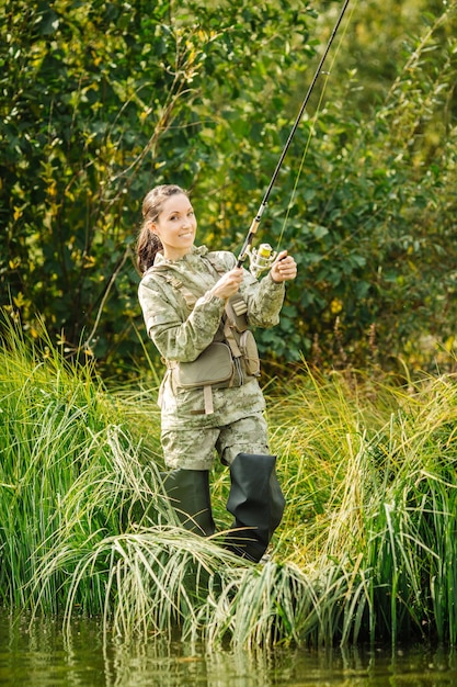 Linda mujer pesca en el río