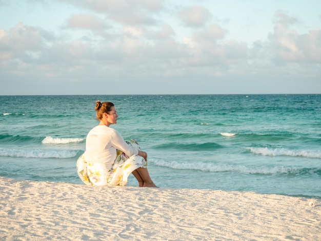 Linda mujer en la playa contra el fondo del mar mirando a lo lejos Al aire libre primer plano Concepto de ocio y viajes