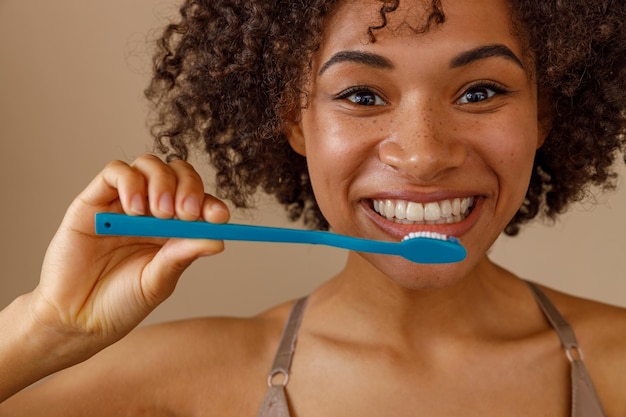 Linda mujer posando con cepillo de dientes en estudio