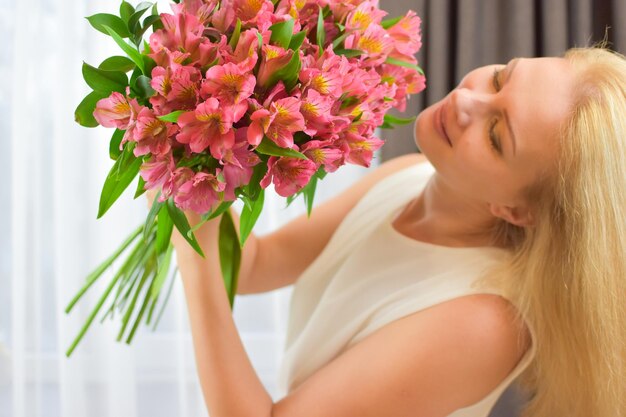 Linda mujer rubia con hermoso ramo de flores frescas ramo para niña entrega de flores