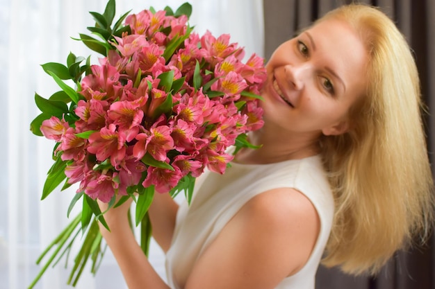 Linda mujer rubia con hermoso ramo de flores frescas ramo para niña entrega de flores