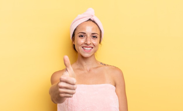 Linda mujer sintiéndose orgullosa sonriendo positivamente con los pulgares arriba ducha y concepto de belleza