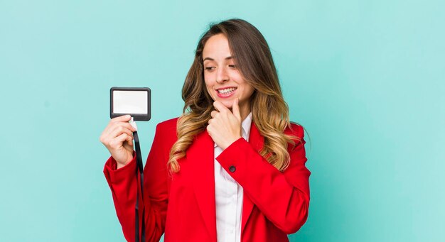 Linda mujer sonriendo con una feliz expresión de confianza con la mano en la barbilla